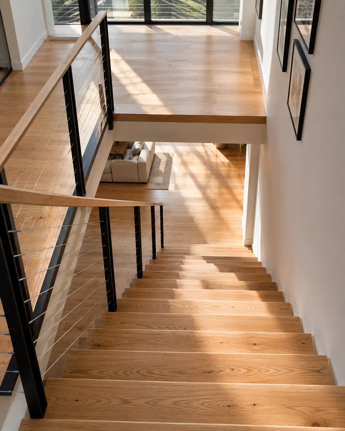 White oak hardwood stair treads on staircase - warm natural finish, matching floor visible at top landing