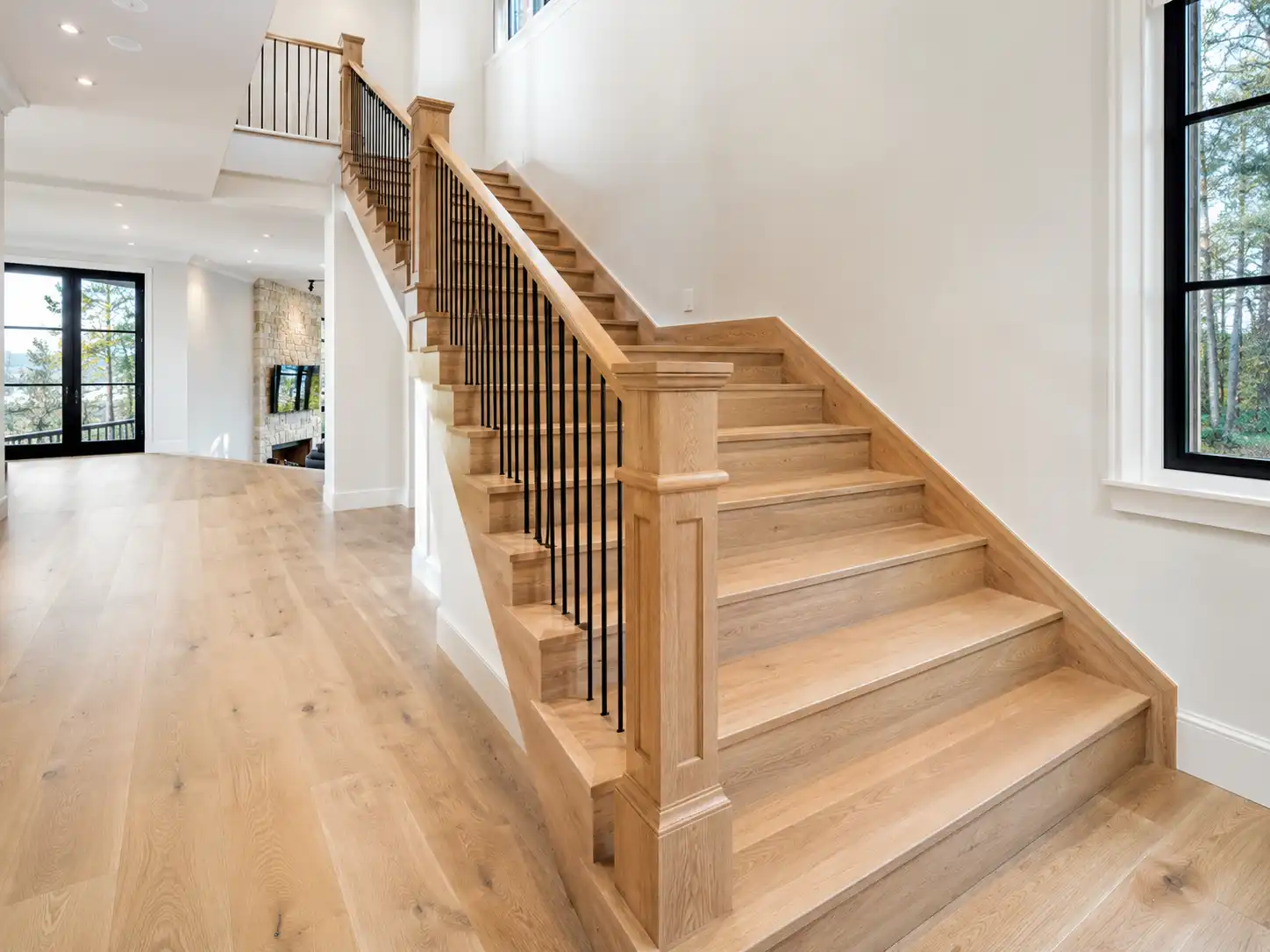 High-end White Oak custom flooring system running uniformly over landings and micro-beveled step nosings