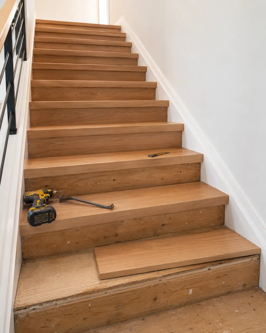 New white oak retrofit stair treads installed seamlessly over an existing plywood sub-tread framework